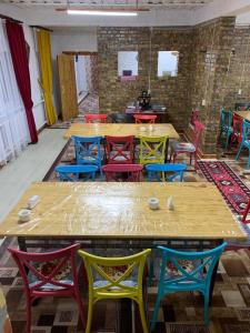 Habitación con mesas de madera y sillas coloridas. en Kolsay Aisha, en Saty