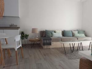 ein Wohnzimmer mit einem Sofa und einem Tisch in der Unterkunft Precioso Apartamento a 20 metros del mar in Agua Amarga