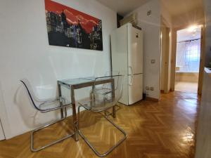 einen Glastisch und zwei Stühle in einem Zimmer in der Unterkunft FUENCARRAL BARCELO Apartaments PARKING TPH in Madrid