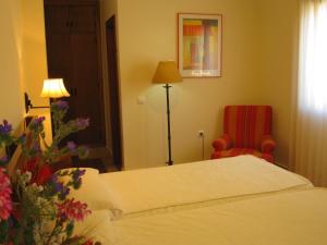 
a bedroom with a bed and a dresser at Hotel Sindhura in Vejer de la Frontera
