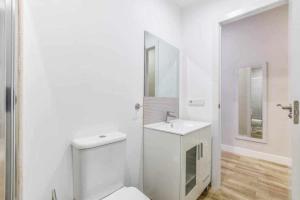 uma casa de banho branca com um WC e um lavatório em Acogedor Apartamento entre Sol Gran Vía y Palacio em Madri