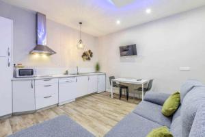 uma cozinha e sala de estar com um sofá e uma mesa em Acogedor Apartamento entre Sol Gran Vía y Palacio em Madri