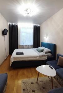 a bedroom with a bed and a couch and a table at Kremlyovskaya Apartament in Vladimir