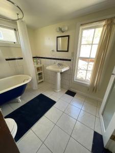 a bathroom with a tub and a sink and a window at 7min Walk to Courthouse Plaza! Historic Cottage in Prescott