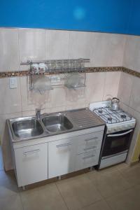 eine kleine Küche mit einer Spüle und einem Herd in der Unterkunft Casa en Cafayate in Cafayate