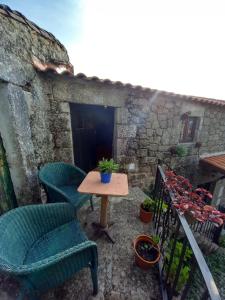 Un patio con sillas y una mesa en el balcón. en Casa da Ti Maria Pereira, en Monsanto