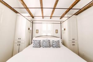 a bedroom with a large white bed with two pillows at Guesthouse Charleston EAST 44 in Charleston