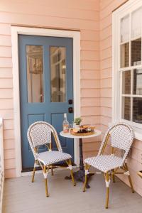 a front door with a table and chairs on a porch at Guesthouse Charleston EAST 44 in Charleston +30 photos