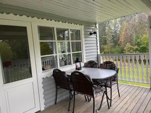 a table and chairs on the porch of a house at Berget in Skillingaryd