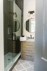 a bathroom with a shower and a sink and a mirror at Guesthouse Charleston EAST 46 E in Charleston