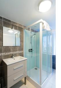 a bathroom with a glass shower and a sink at La Maison De L'union in Gérardmer