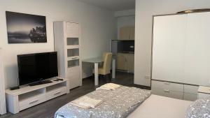 a bedroom with a television and a table with a bed at Pension Neon in Mannheim