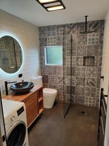 a bathroom with a shower and a toilet and a sink at Casa Harpers in White Beach