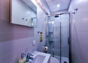 W łazience znajduje się umywalka i przeszklony prysznic. w obiekcie FLH Faro Spacious Flat with Balcony w Faro