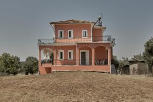 a large pink house on a hill with trees at Villa Ancient Olympia by PCL in Pelópion