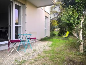a table and chairs on the side of a house at Appartement Toulouse Blagnac MEET Aéroport 5 min Tramway à 6 min free Parking Proche de toutes commodités Belle terrasse in Blagnac