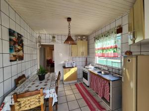 a kitchen with a table and a sink and a refrigerator at Casa Açores Residencial - Apartamentos Praia dos Ingleses Floripa SC in Florianópolis