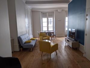 a living room with a couch and chairs and a tv at Logis de la Grande Rue, appt cœur de ville, spacieux, lumineux, parquet 3 chbres, - 6 pers in La Flèche