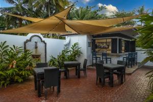 a patio with tables and chairs and a bar at Casa Isleña in Rincon
