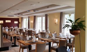 een eetkamer met houten tafels en stoelen bij Typically Swiss Hotel Altana in Scuol