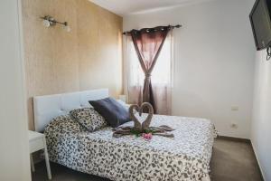 a bedroom with a bed with a leopard print sheets and a window at Mirador del Atlántico in Los Quemados