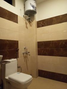 Jungle Bell Resort في لاتاغري: حمام به مرحاض وضوء على الحائط