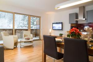 ein Esszimmer und ein Wohnzimmer mit einem Tisch und Stühlen in der Unterkunft Steinbock Superior Appartement in Zell am See