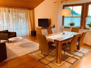 een woonkamer met een houten tafel en stoelen bij Haus Helga in Hof bei Salzburg