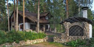 a house with a stone fireplace in front of it at Chalet Ray Holiday Home in Klevernoye