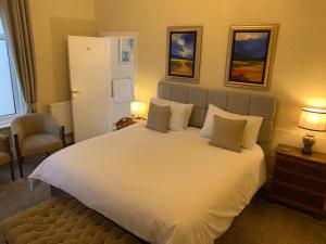 una camera da letto con un grande letto bianco con due cuscini di The Gaydon a Lytham St Annes