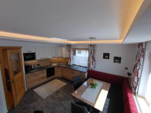 a kitchen with a table and a red couch at Komfort Appartements Talbach in Hippach