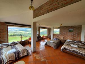 a bedroom with two beds and a brick wall at Balcon al Cotopaxi Hosteria in Sangolquí