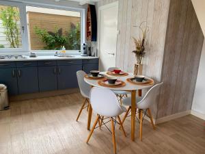 uma cozinha com uma mesa e cadeiras e um lavatório em Pollux bij Vuurtoren en strand em Noordwijk aan Zee