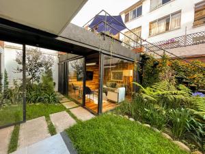 a glass extension to a house with a garden at Lucitania Hotel Boutique in Bogotá