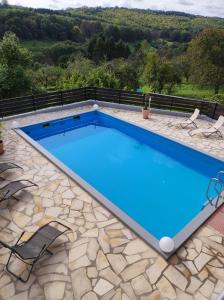 a large swimming pool with a stone patio and blue water at Kohlwies 