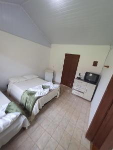 a bedroom with two beds and a television in it at Estancia santa Rita in Joanópolis
