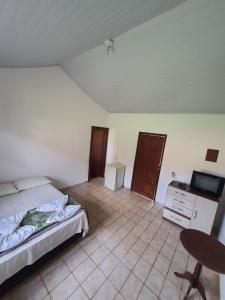 a bedroom with a bed and a desk and a television at Estancia santa Rita in Joanópolis