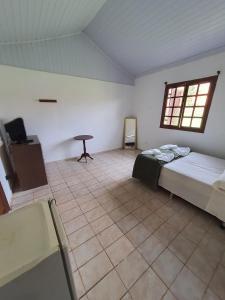 a room with a bed and a table in it at Estancia santa Rita in Joanópolis