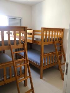 two bunk beds in a room with a window at APTO FAMILIAR EM BERTIOGA JARDINS DO INDAIÁ A 500 M Praia in Bertioga +10 photos