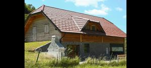 une grande maison en bois avec un toit rouge dans l'établissement Ranč Stojnšek, à Rogaška Slatina