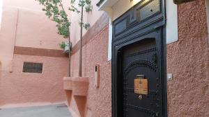 a black door on the side of a brick building at Riad Les Nuits de Marrakech in Marrakesh