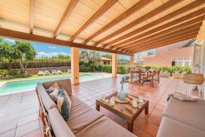 un patio con sofá, mesa y piscina en Villa Joana Barcares for 10 with swimming pool, en Alcudia 49 fotos más