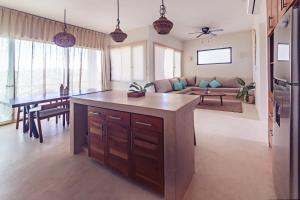 a kitchen and living room with a table and a couch at Casa Astral Luxury Hotel in Holbox Island