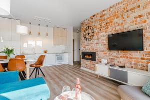 a living room with a brick wall at Grobla by Loft Apartments in Gdańsk