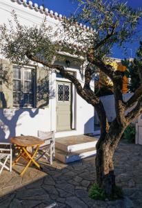 a table and a tree in front of a house at Aria House in Spetses