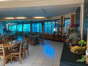 a restaurant with wooden tables and chairs and windows at Hotel St. Daniel in Guarulhos