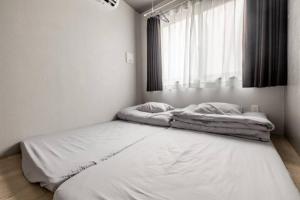 two beds in a white room with a window at Marvelous Ryogoku - Vacation STAY 74210v in Tokyo