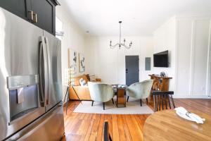 a kitchen and living room with a refrigerator and a table at Guesthouse Charleston EAST 46 G in Charleston +6 photos