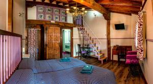 a room with a bed and a spiral staircase at La Casa del Burro in La Alberca