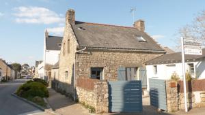 a stone house with a blue gate in a street at Jolie maison de Pêcheur - Sweet Fisherman Cottage in Saint-Philibert
